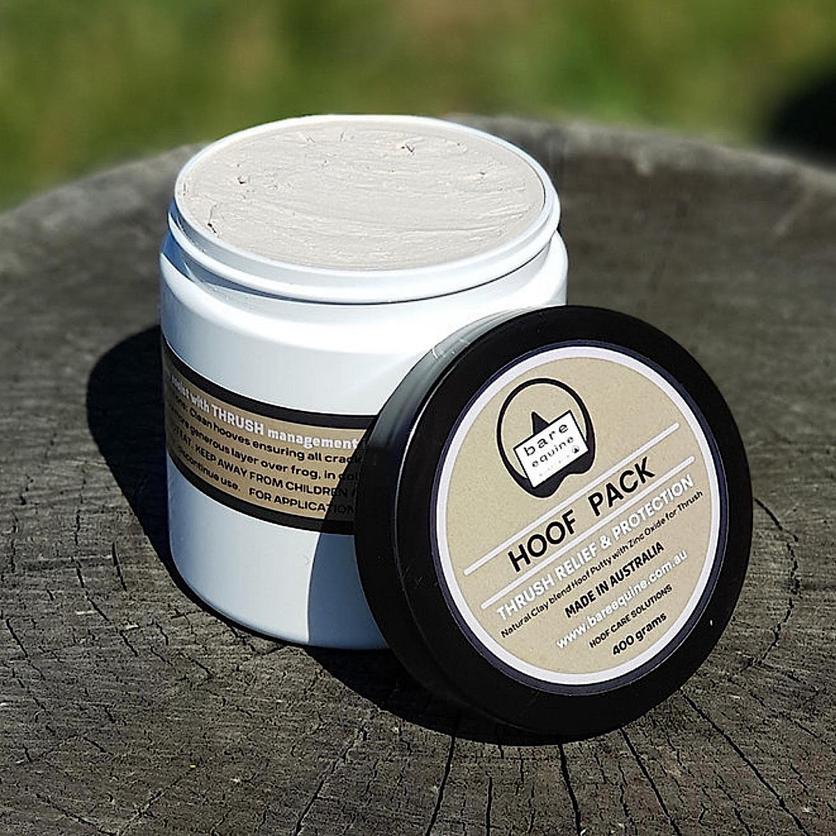 Large white cylindrical tub of hoof pack with black screw lid.