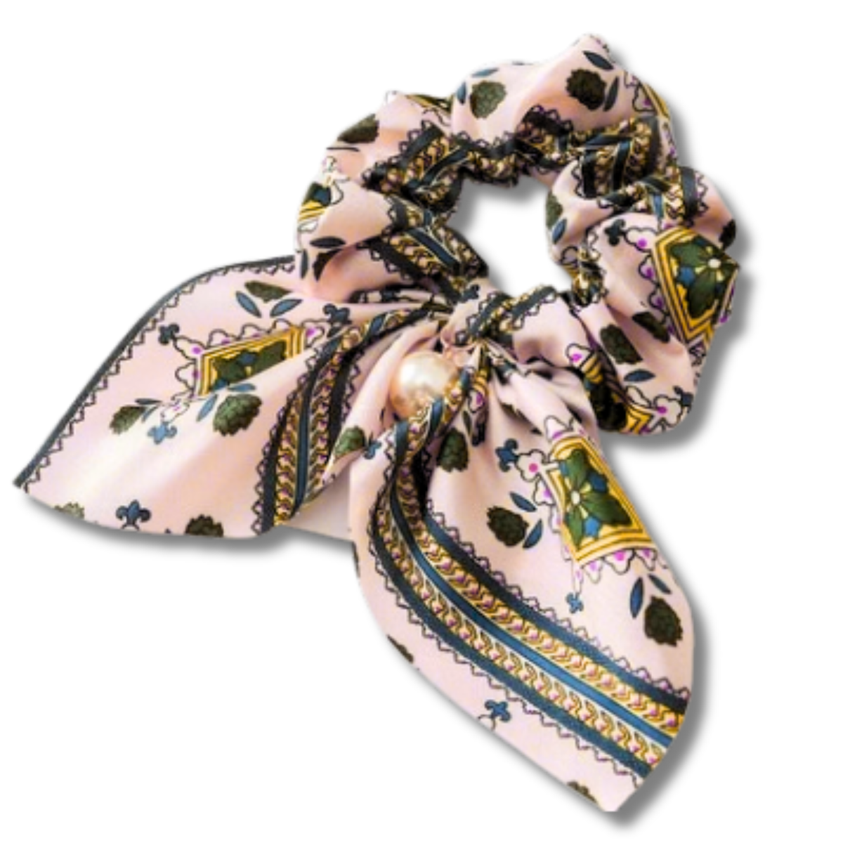 A pink silk scrunchie with a decorative pearl, featuring a botanical and geometric pattern in green, gold, and navy on a white background.