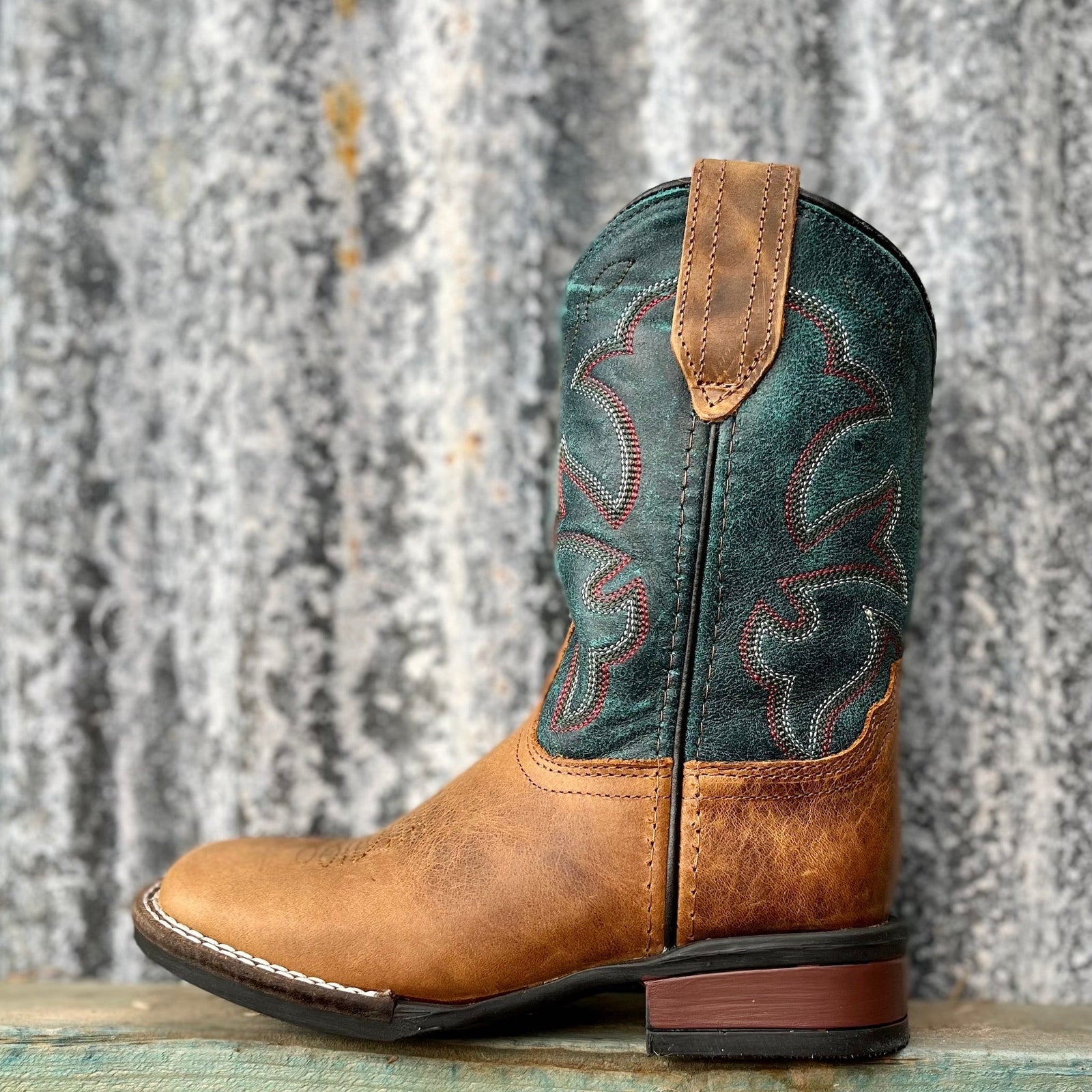 light brown boots with teal blue upper and red and white stitch detailing